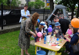 Dzieci wraz z rodzicami pompują balony przy pomocy octu i sody oczyszczonej